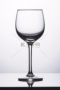 白色背景的桌子上放着一个透明的酒杯