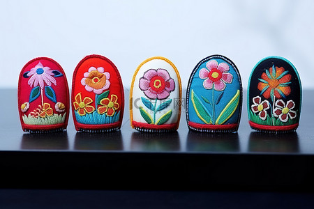 五个绣花形状的指甲，每一个都装饰有五颜六色的花朵