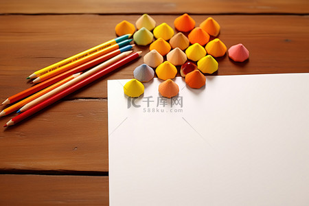 木桌上的彩色铅笔和纸，配有彩色蜡笔