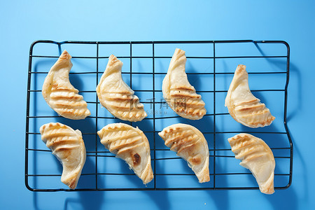 厨房简笔背景图片_蓝色背景中烤架上的鱼糕点