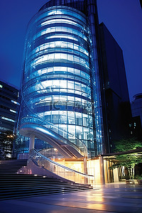 城市楼梯背景图片_通向大楼的玻璃楼梯附近夜间有灯光的建筑物