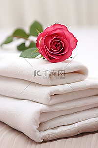 毛巾花背景图片_一朵粉红玫瑰坐在四块亚麻毛巾的中间