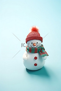 蓝色表面戴着红白羊毛帽的小雪人