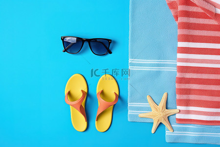 两双蓝色人字拖太阳镜和沙滩巾