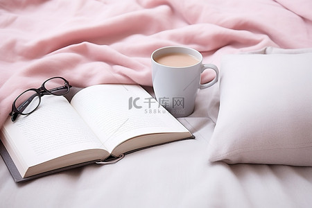 枕头上放着两个咖啡杯和一本打开的书