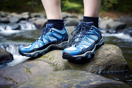 溪边岩石上的蓝色步行鞋