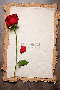 桌子上的一张纸和一朵红玫瑰