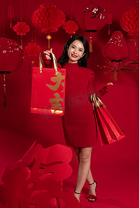 春节年货促销摄影照片_新年购物红色背景下的一位亚洲青年女性拿着购物袋
