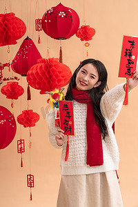 拜年拜年摄影照片_新年祝福一位亚洲青年女性拿着春联