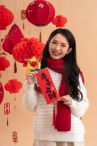 春节习俗摄影照片_新年祝福一位亚洲青年女性拿着春联