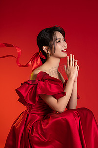 小年扫尘土习俗摄影照片_新年气氛红色背景下的一位亚洲青年女性