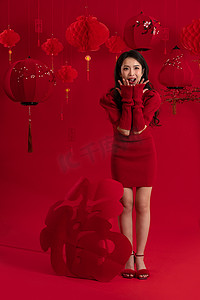 传统习俗剪纸摄影照片_新年气氛红色背景下的一位亚洲青年女性