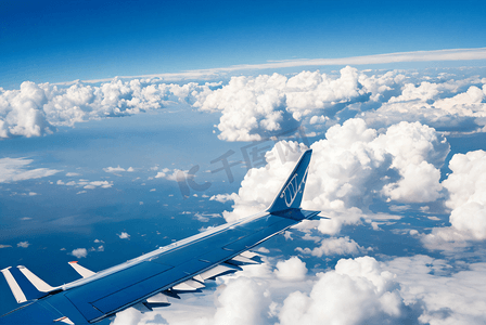 在蓝天白云下自由飞行的飞机摄影图