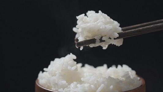 白米白面摄影照片_筷子夹起热气大米饭实拍1080