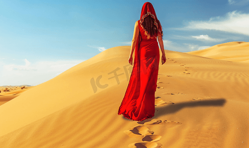大漠风沙摄影照片_走在沙漠里的红衣美女
