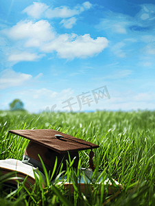 素材毕业学士帽摄影照片_大学草地上的书本证书学士帽