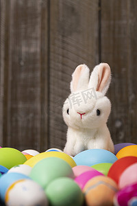 彩绘蛋摄影照片_兔子彩蛋复活节木制背景