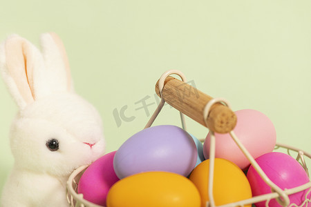 彩绘蛋摄影照片_彩蛋兔子复活节绿色背景