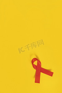 慈善公益爱心慈善摄影照片_红丝带公益关爱黄色背景
