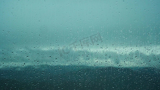 阴天下雨雨滴摄影照片_实拍阴天下雨天雨天玻璃上雨水滑落忧郁心情