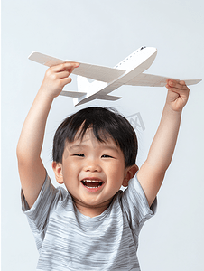 纸飞机飞机摄影照片_亚洲人快乐的小男孩玩开飞机游戏