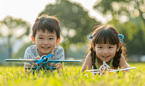 黄色可爱摄影照片_亚洲人拿着玩具飞机在公园玩耍的快乐儿童