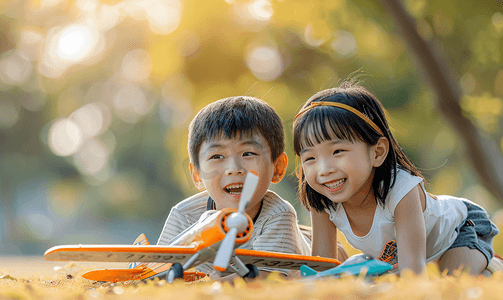 中国飞机摄影照片_亚洲人拿着玩具飞机在公园玩耍的快乐儿童