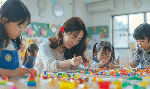 学生幼儿园摄影照片_亚洲人幼儿园的师生在做手工