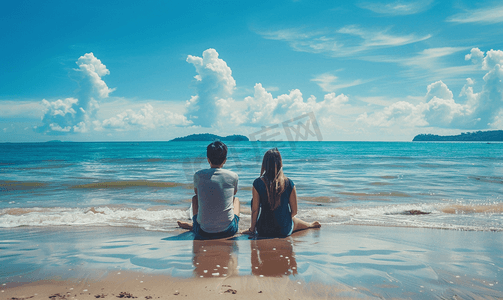 海边沙滩度蜜月摄影照片_海边情侣坐在沙滩看大海背影