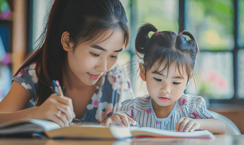 中国结过年摄影照片_亚洲人辅导女儿做作业的青年女人