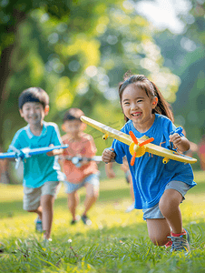 秋天摄影照片_亚洲人拿着玩具飞机在公园玩耍的快乐儿童