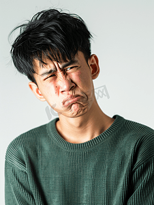 头痛摄影照片_亚洲人面部表情痛苦的青年男人
