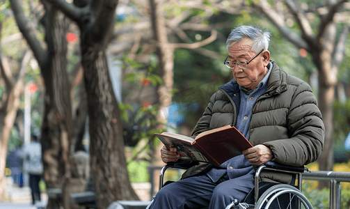 老年人摄影照片_亚洲人户外老年男人坐在轮椅上看书