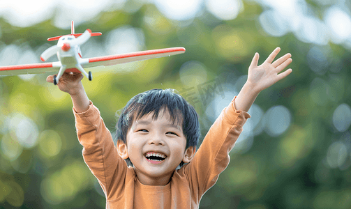 嬉戏的摄影照片_亚洲人快乐的小男孩玩开飞机游戏