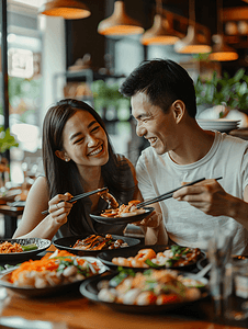 亚洲人快乐情侣在餐厅里用餐