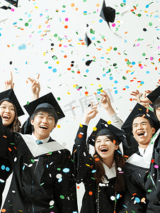 毕业青年剪影摄影照片_亚洲人穿学士服的大学生欢呼庆祝毕业4