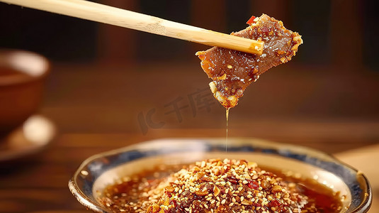 筷子夹着一块肉烧烤蘸酱照片