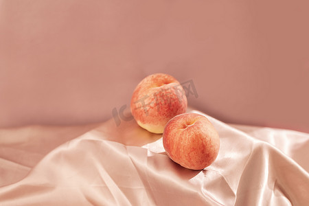 饮品海报背景摄影照片_两颗毛桃桃子粉色场景