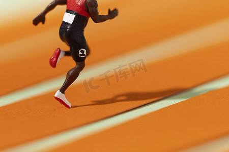 摄影照片_奔跑的运动员在赛道上创意图片
