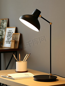 现代办公桌上的黑色台灯摄影图