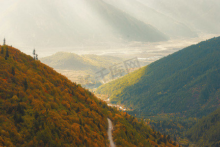 蜿蜒的公路摄影照片_西藏林芝色季拉山秋韵光影交织的壮丽画卷