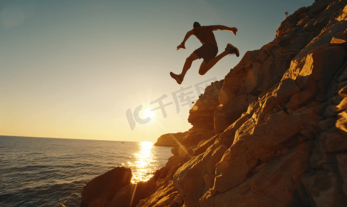 跳跃剪影摄影照片_一名运动员在岩石悬崖上跳跃的剪影