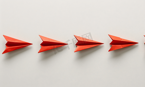 ppt模板折纸课摄影照片_用红色纸飞机在一排白色飞机之间改变概念思考不同