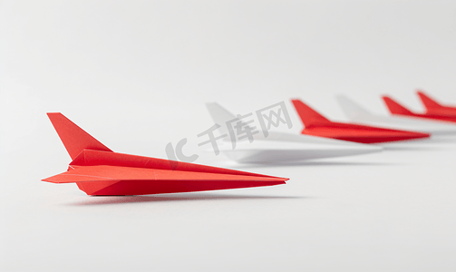红色喜庆开业摄影照片_用红色纸飞机在一排白色飞机之间改变概念思考不同