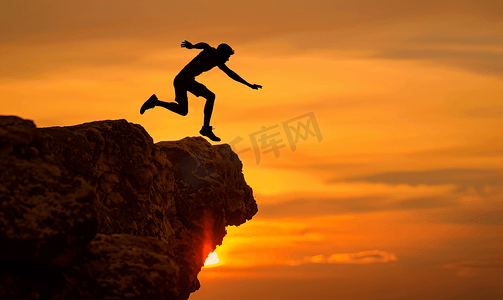 一名运动员在岩石悬崖上跳跃的剪影