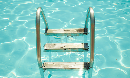 太阳表面摄影照片_清澈的游泳池梯子的金属栏杆
