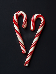 新年糖果摄影照片_圣诞快乐新年贺卡黑色背景中的两根棒棒糖