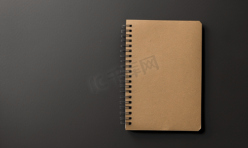 铅笔字帖摄影照片_设计理念黑色背景模型上空牛皮纸笔记本的顶视图