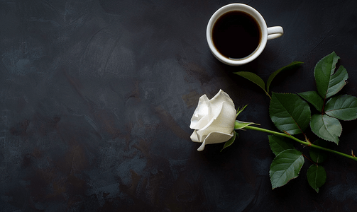 黑色杯子上摄影照片_黑色背景上的一杯黑咖啡和白玫瑰顶视图复制空间