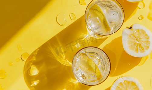 黄色液体摄影照片_黄色背景中带苹果汁和苏打水的透明玻璃的顶视图